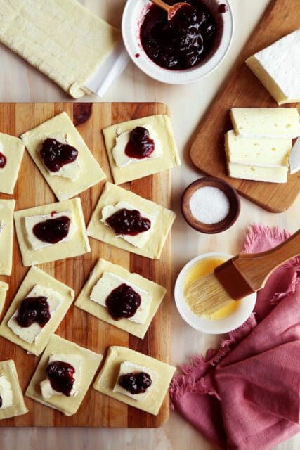 Small pieces of puff pastry topped with brie and cherry jam.