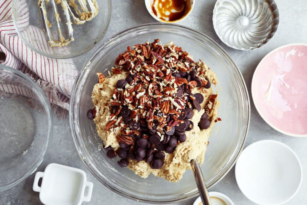 Pecans and chocolate chips to cookie dough.
