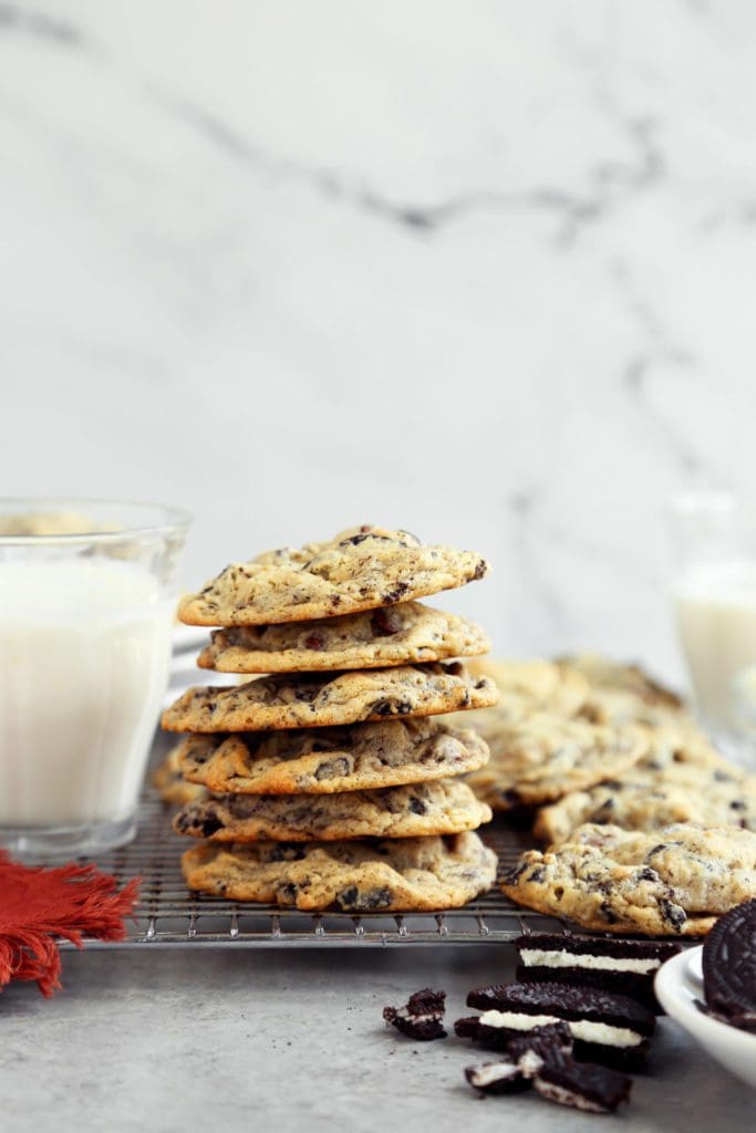 stack of cookies and cream cookies on a rack with glass of milk