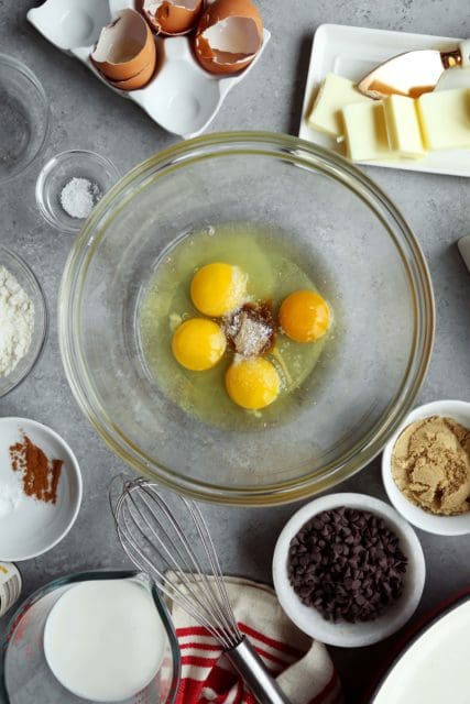 Eggs in a clear bowl with sugar and vanilla