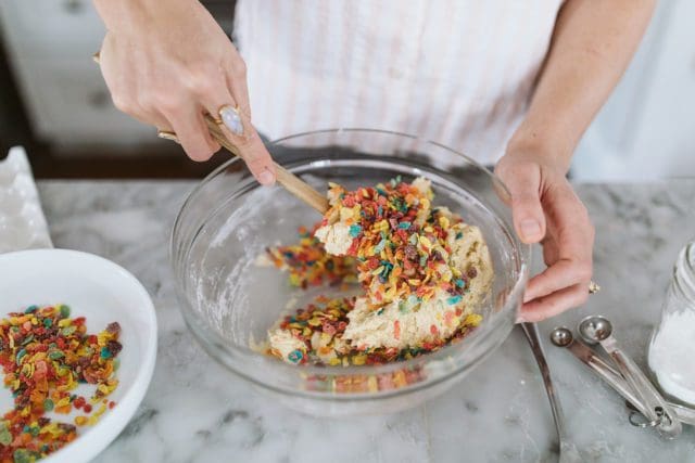 Stirring Fruitti Pebbles into cookie batter. 