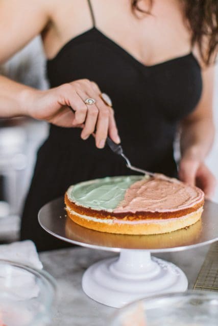 Smoothing strawberry pudding over doberge cake layer.