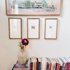 books on a bench with framed art above