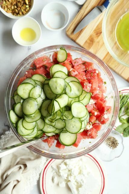 Cucumber sliced and watermelon in a large salad bowl