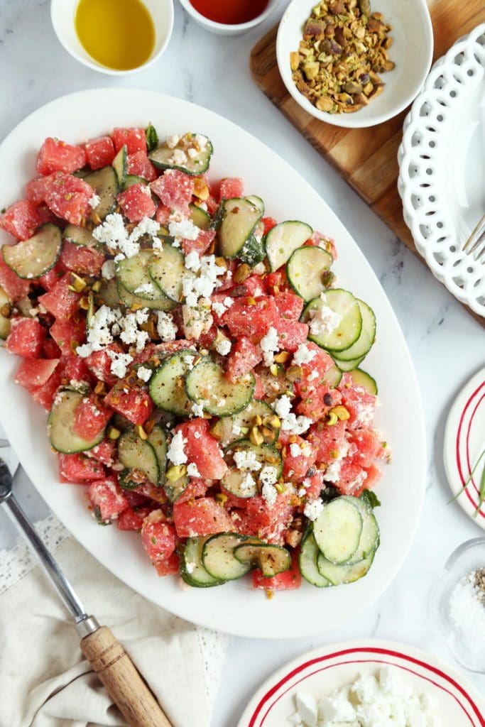 Watermelon salad with cucumber and feta arranged on a platter.