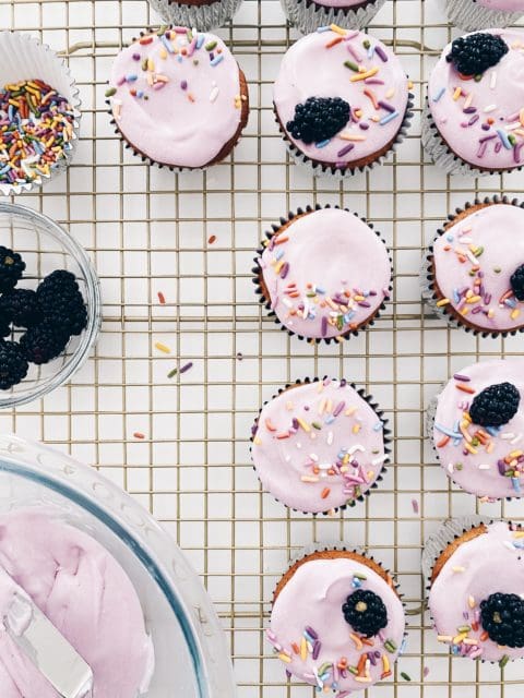 purple frosted cupcakes on a wire rack