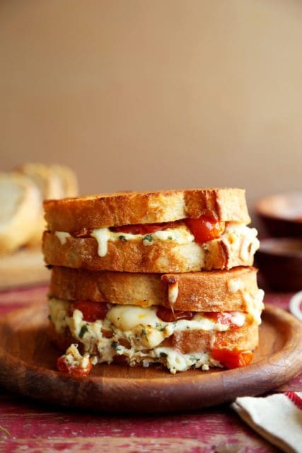 Side view of gooey lasagna grilled cheese sandwiches.