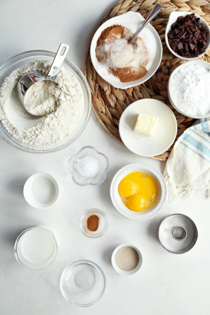 Ingredients for classic yeast doughnut recipe in small bowls.