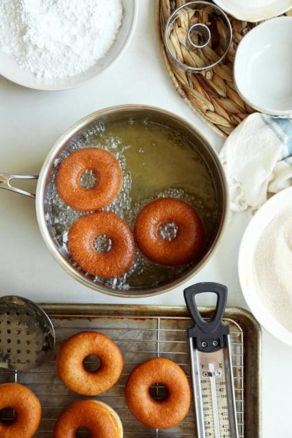 Doughnuts frying to golden in hot oil.