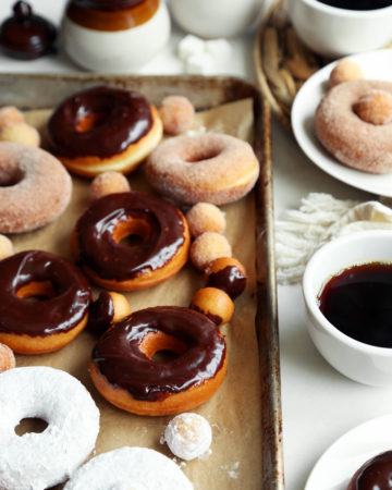 Classic yeast doughnut recipe glazed and sugared on a baking sheet.