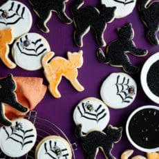 Halloween sugar cookie recipe frosted like black cats and spider webs.