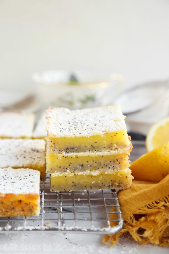 Stack of the perfect lemon bars recipe sliced and cooling on a wire rack.