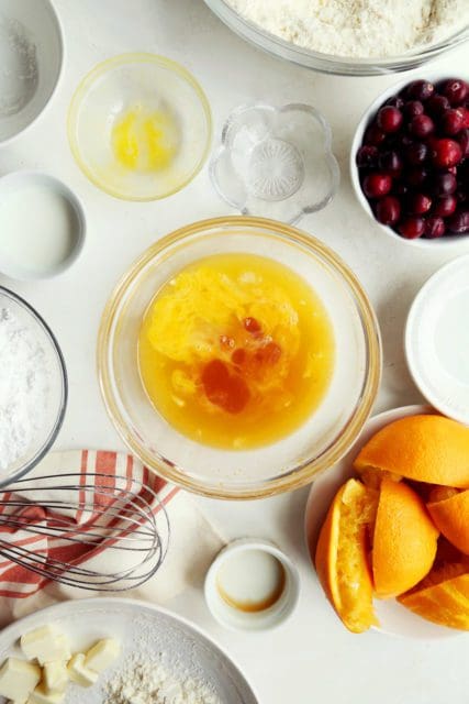 Eggs, orange, and vanilla in a small bowl for cranberry bread.