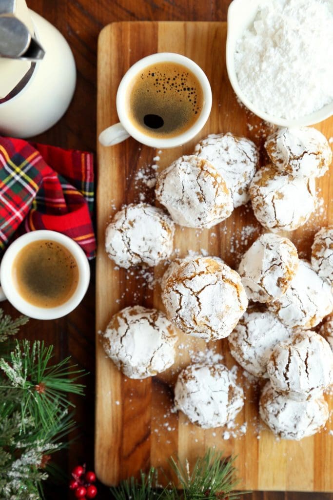 Italian almond flour cookies covered in powdered sugar on a board.
