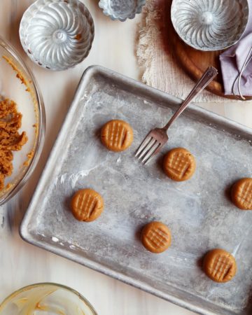 Peanut butter cookie dough balls on a baking sheet.