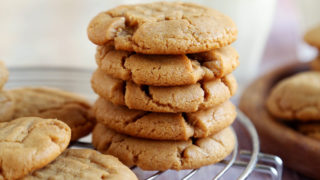 Crisp, salty, sweet peanut butter cookie recipe stacked on rack,