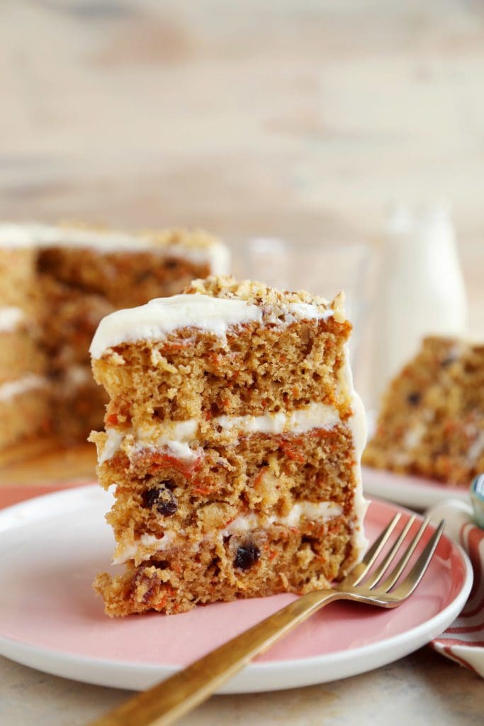 Slices of carrot cake standing on a plate with fork.