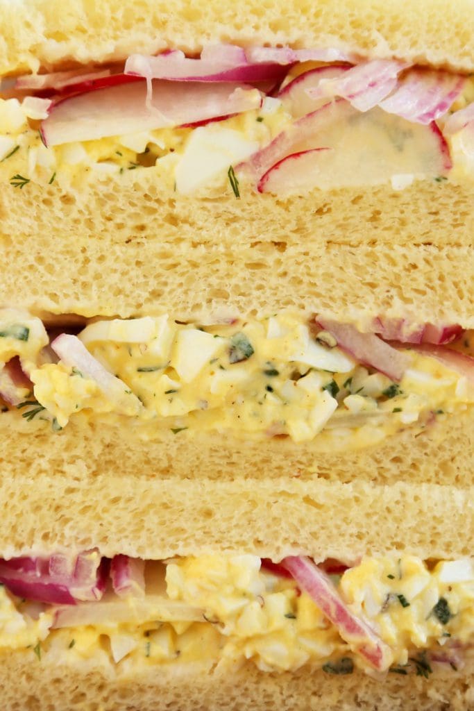 Close up picture of egg salad sandwich on potato bread.