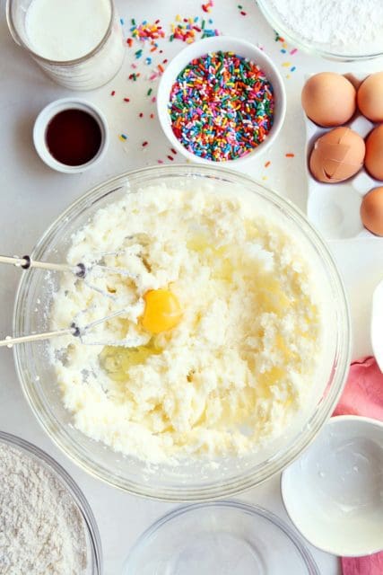 Eggs added to funfetti cake batter in large bowl.