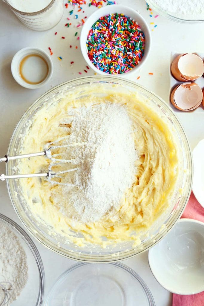 Dry ingredients added to wet ingredients for funfetti birthday cake.