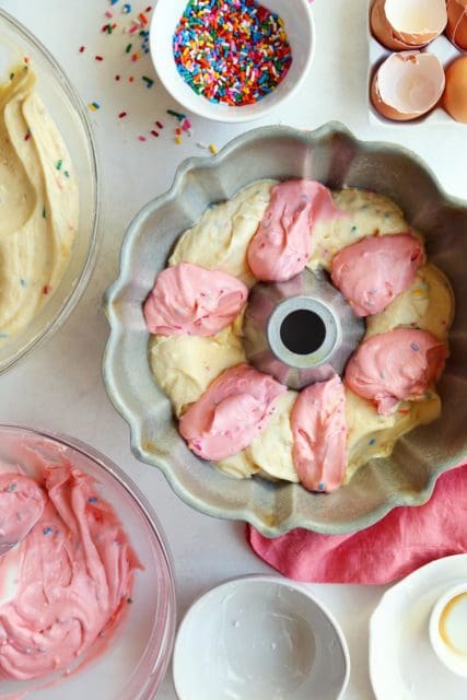 Bundt pan with pink and yellow funfetti cake batter.