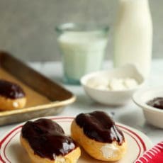 Two chocolate topped eclairs on a plate