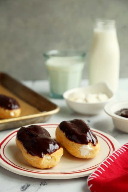 Two chocolate topped eclairs on a plate