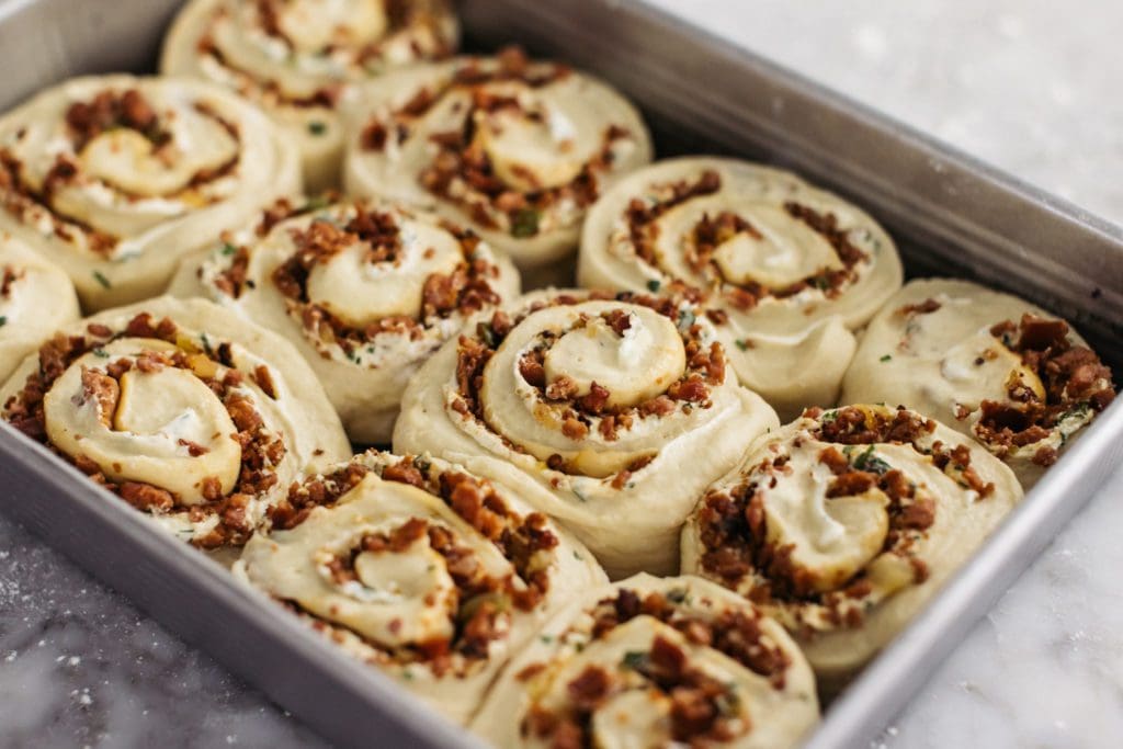 Risen rolls in baking pan ready to bake.