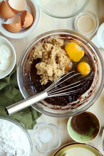 Mixing brown sugar and eggs into chocolate cake batter.
