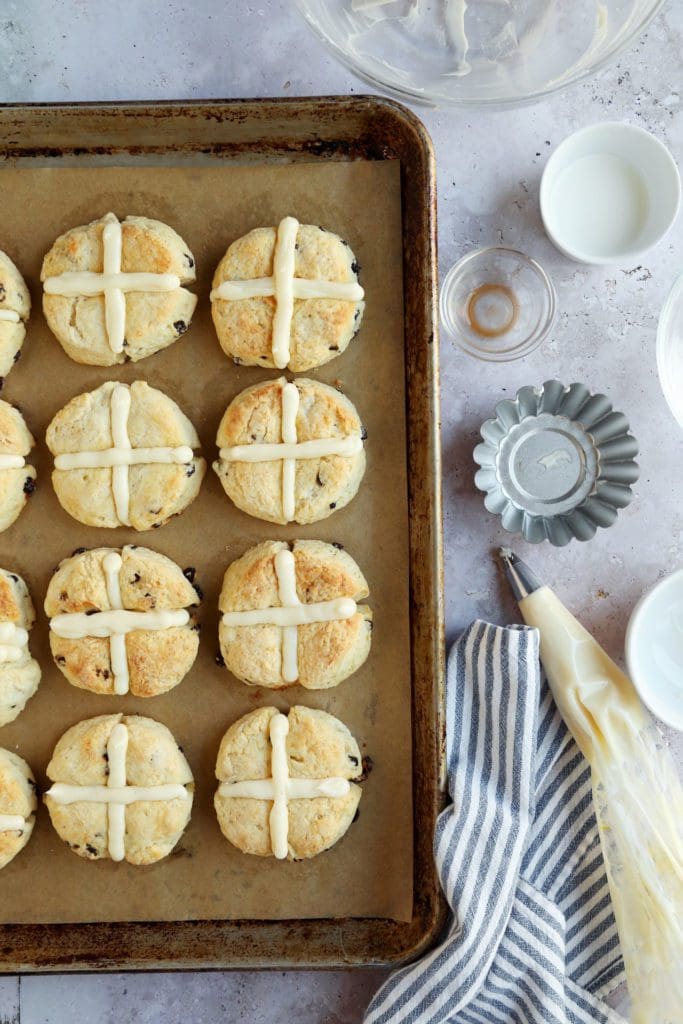 Hot cross biscuits frosted on a baking sheet.