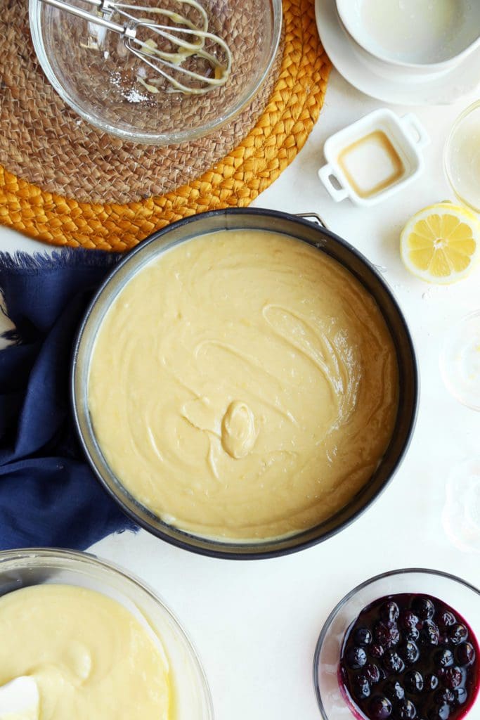 Lemon cream cheese filling on top of cake batter in pan.