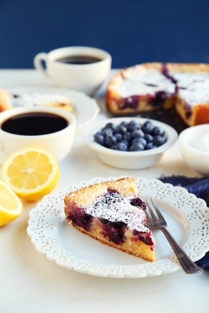 A slice of lemon blueberry cake on a small plate with fork,