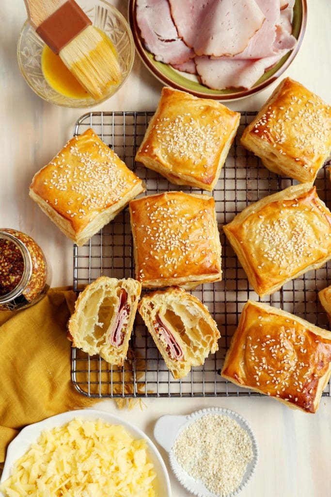 Baked croissants sliced in half on wire rack.