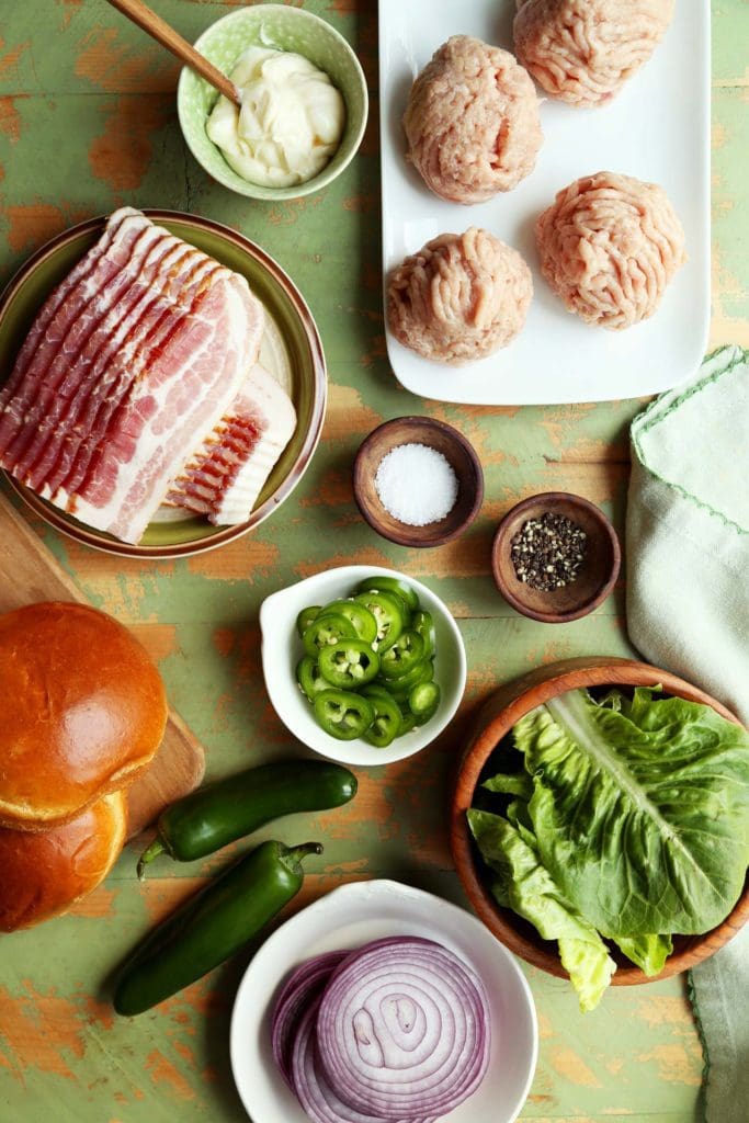 ingredients for chicken burger recipe set on a kitchen conter.