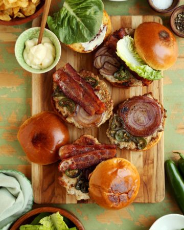 assembling chicken burger on wooden board