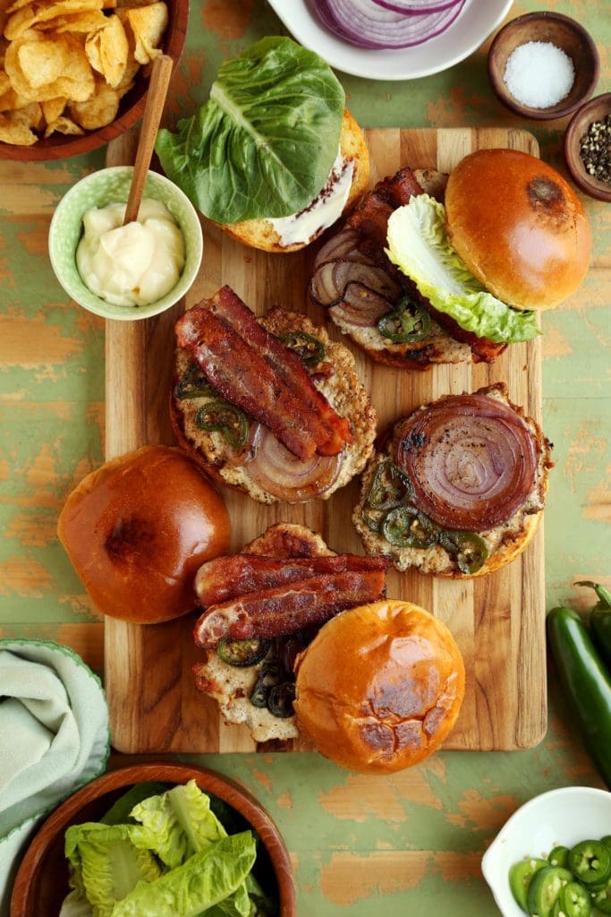 assembling chicken burger on wooden board