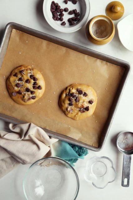 small batch chocolate chip cookie on a parchment lined baking sheet