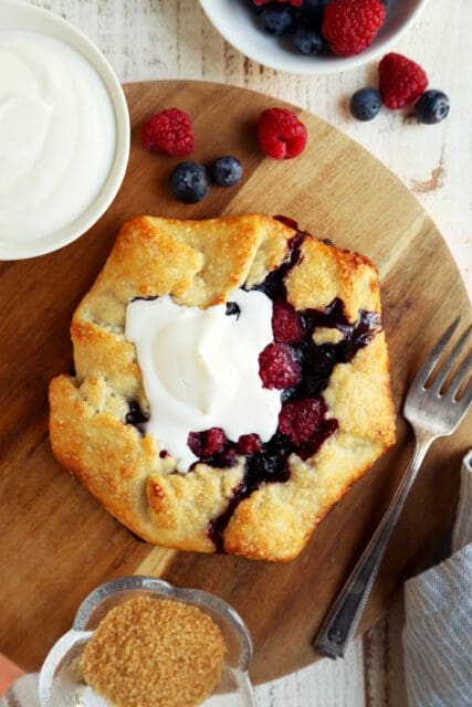 Berry crostata topped with whipped cream with coffee.