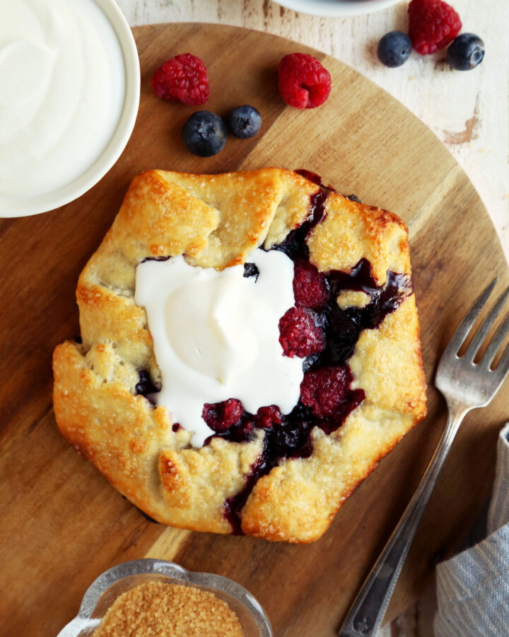 Berry crostata topped with whipped cream with coffee.