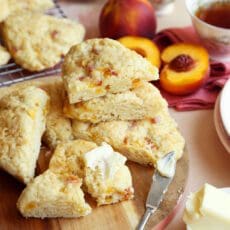 Baked peach scones stacked with butter.
