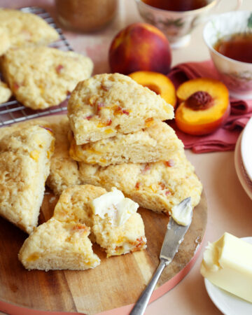 Baked peach scones stacked with butter.