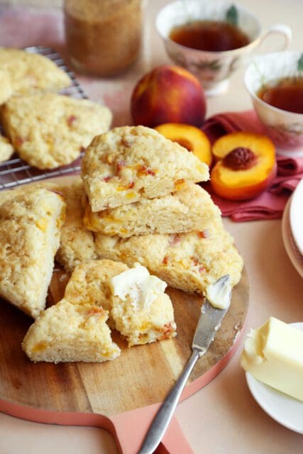 Baked peach scones stacked with butter.