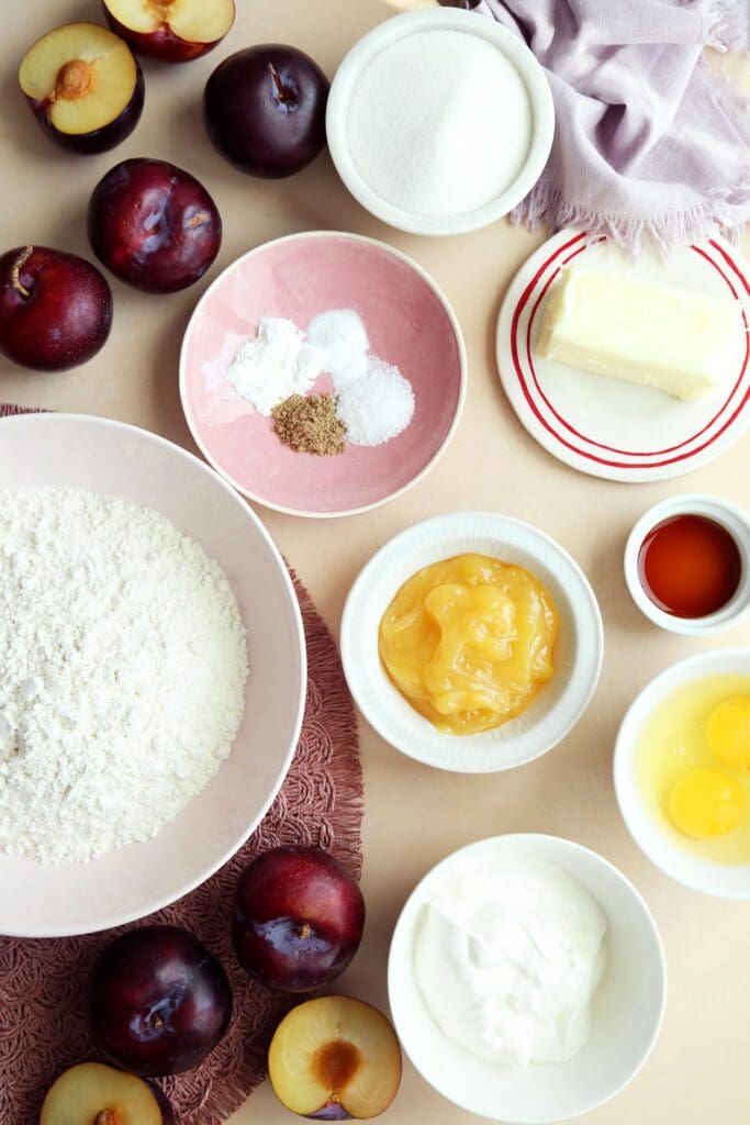Ingredients for plum cake recipe in small bowls.