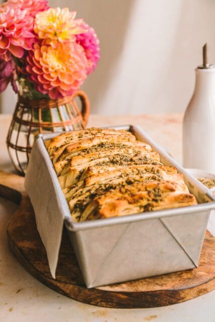 Baked pull apart garlic bread baked in a loaf pan.