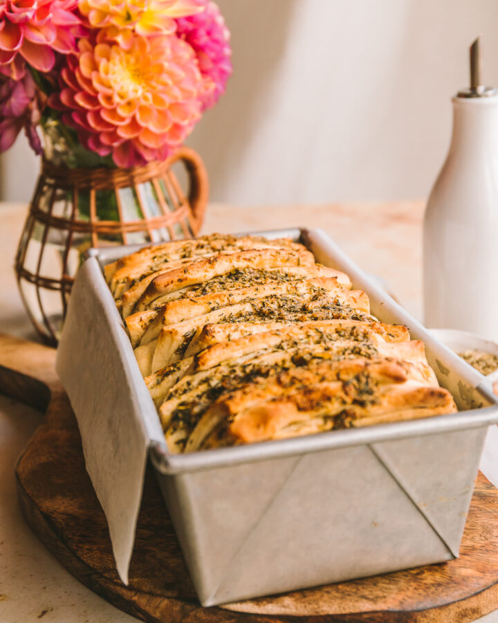 Baked pull apart garlic bread baked in a loaf pan.