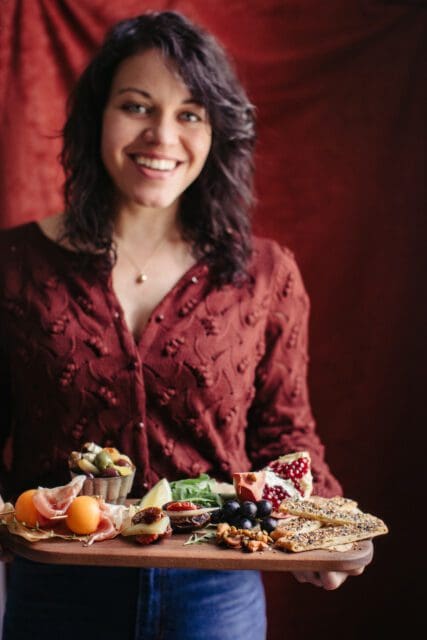 joy holding a board of easy thanksgiving appetizers.