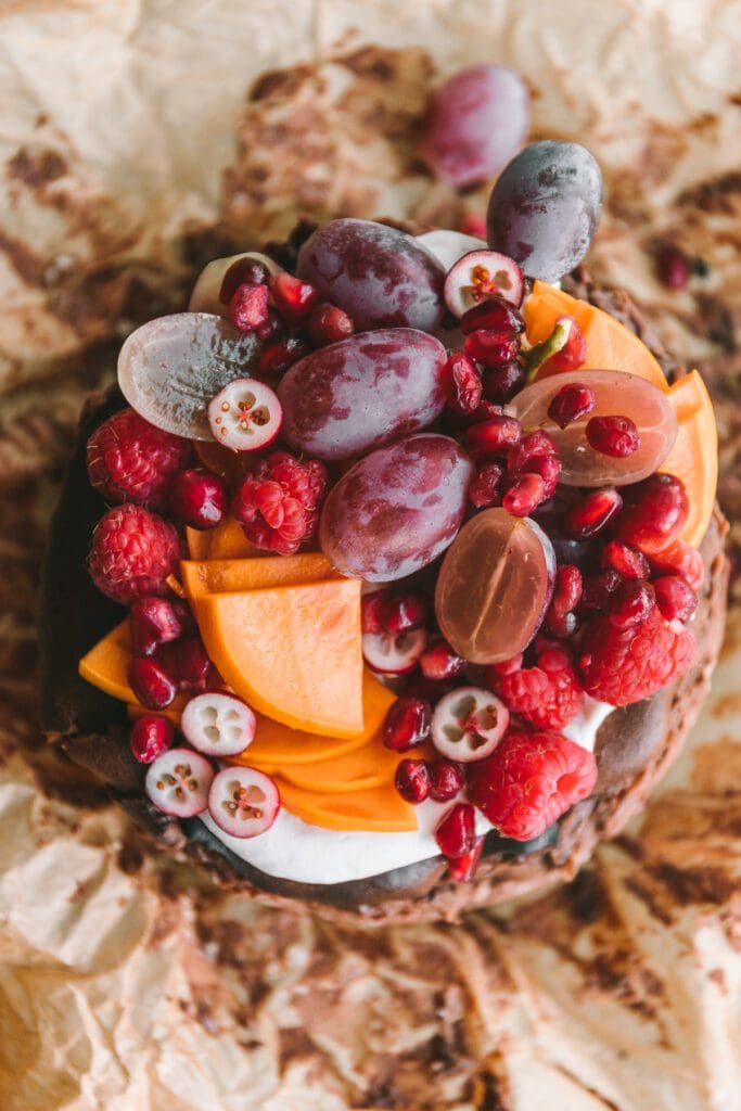 Persimmon, cranberries and grapes on top of chocolate cheesecake.