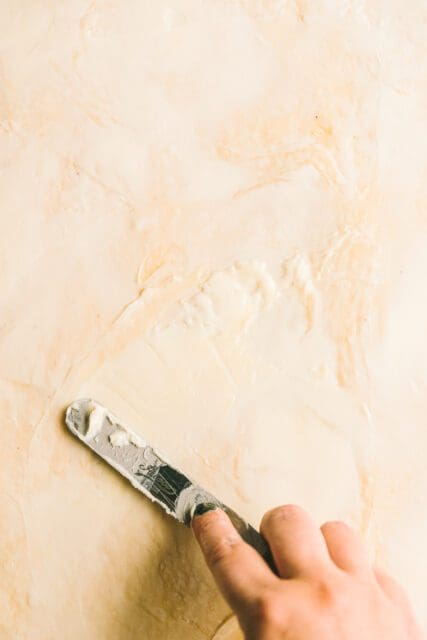 Spreading butter over rolled out dough