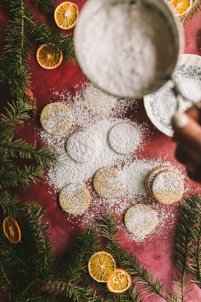 Dusting linzer cookies with powdered sugar