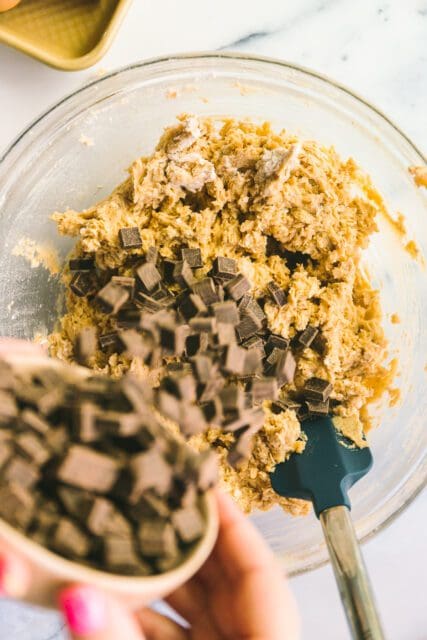 adding chocolate into cookie dough for cookies.